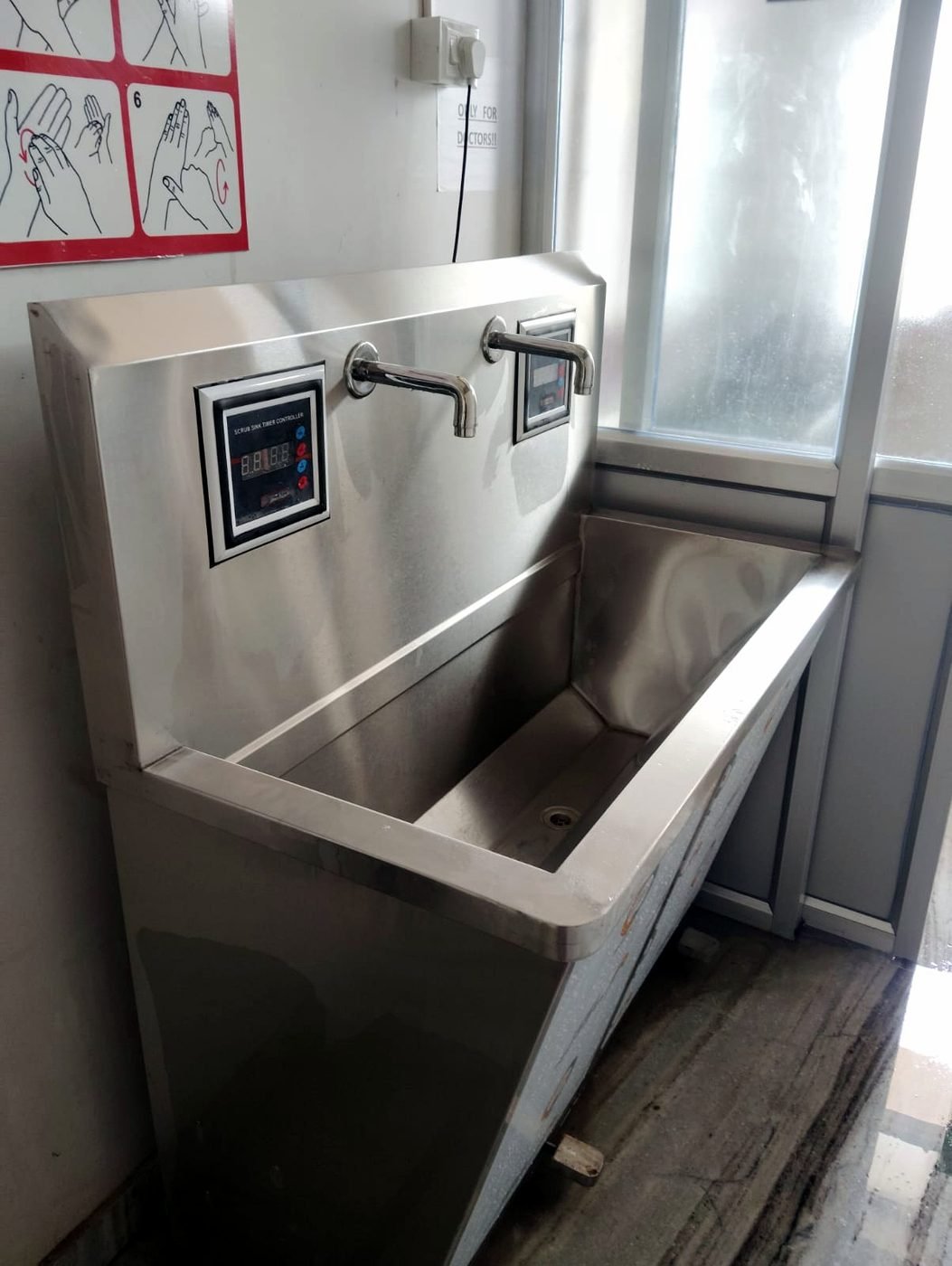 Stainless-steel surgical scrub sink with sensor taps and scrub timer at Narayan Hospital